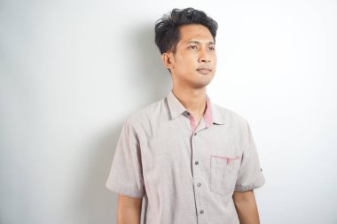 Portrait of Asian young man wearing pink shirt isolated on white.