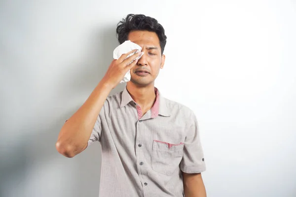 Funny asian man crying wipes tears losing his job.