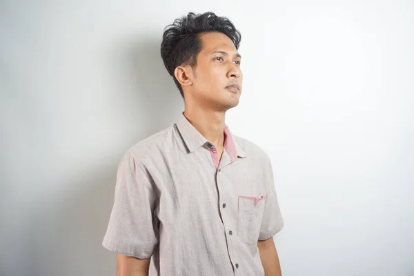 Portrait of Asian young man wearing pink shirt isolated on white.