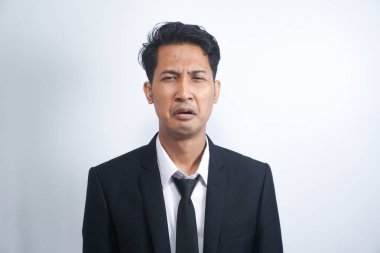 Takım elbiseli, ağlayan, hıçkıra hıçkıra ağlayan, üzgün hisseden, beyaz arka planda duran sefil adamın yakın çekimi.