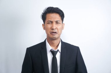 Takım elbiseli, ağlayan, hıçkıra hıçkıra ağlayan, üzgün hisseden, beyaz arka planda duran sefil adamın yakın çekimi.