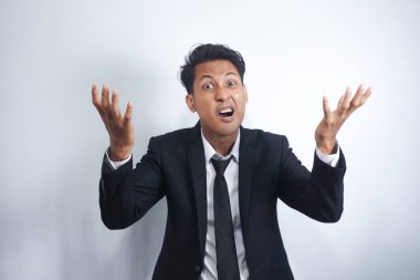 Angry man gesturing angrily raising hands and shouting loudly expressing anger after quarrel with boss or employee in suit isolated over white background. Feel my anger