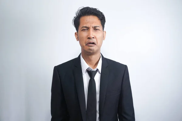 Close-up of miserable man in suit, crying and sobbing, feeling sad, standing against white background