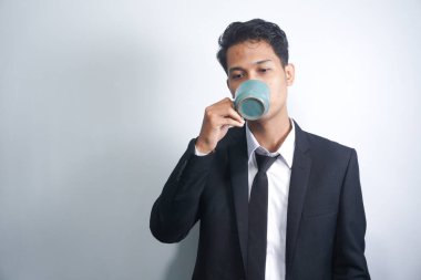 Bir fincan kahve ya da çay içen genç iş adamı.