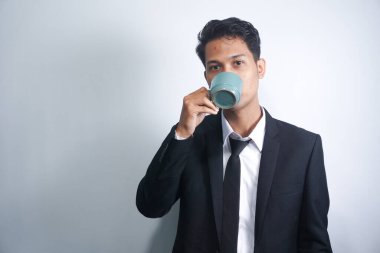 Bir fincan kahve ya da çay içen genç iş adamı.