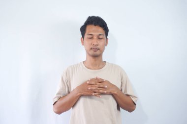 Young handsome man wearing cream t shirt over white background very happy and excited doing winner gesture with arms raised, smiling and screaming for success. Celebration