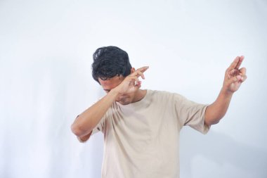Young handsome man wearing cream t shirt over white background very happy and excited doing winner gesture with arms raised, smiling and screaming for success. Celebration