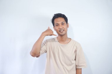 give me a call. Portrait of positive optimistic man smiling at camera, making call me gesture with fingers, flirting. Indoor studio shot isolated on white background.
