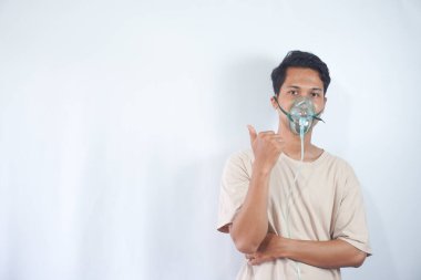 unhealthy young man wearing oxygen mask, and pointing