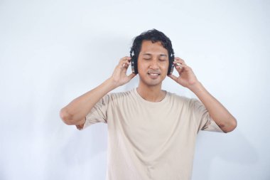 Peaceful positive modern man have black wireless headset listen music enjoy song melody close eyes feel pleasure wear casual style clothes isolated over white color background