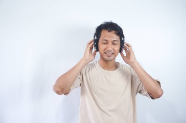Peaceful positive modern man have black wireless headset listen music enjoy song melody close eyes feel pleasure wear casual style clothes isolated over white color background