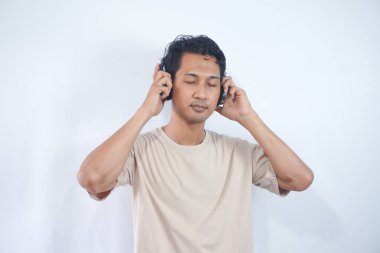 Peaceful positive modern man have black wireless headset listen music enjoy song melody close eyes feel pleasure wear casual style clothes isolated over white color background