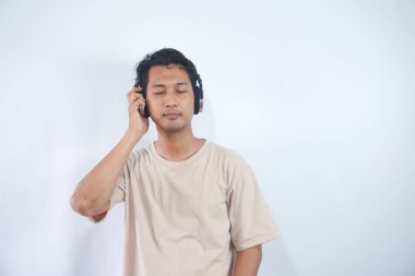 Peaceful positive modern man have black wireless headset listen music enjoy song melody close eyes feel pleasure wear casual style clothes isolated over white color background