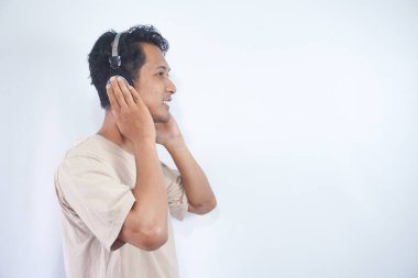 Peaceful positive modern man have black wireless headset listen music enjoy song melody close eyes feel pleasure wear casual style clothes isolated over white color background