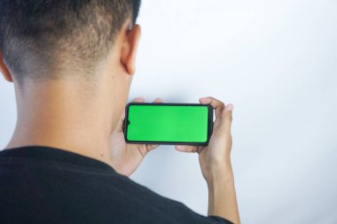 Close up shot of man holding a smartphone with chroma key mock up green screen - technology, connections, communications concept