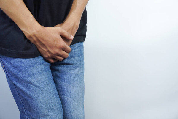 Close up of a man with hands holding his crotch, Urinary Tract Infection concept Painful Bladder Syndrome and interstitial cystitis