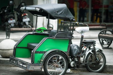 Becak motoru ya da taksi şoförü Malioboro caddesinde yolcu bekliyor..