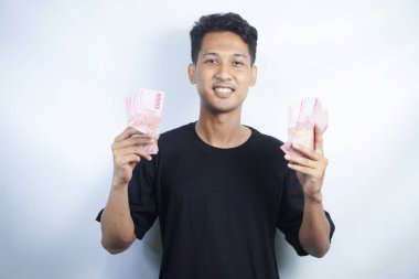 Şok olmuş ve yakışıklı Asyalı bir adamın beyaz duvar arkasında izole edilmiş bir şekilde poz verişi.