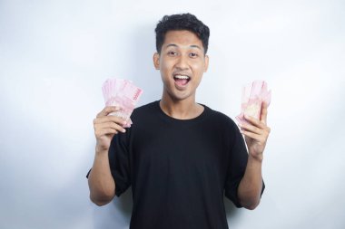 Şok olmuş ve yakışıklı Asyalı bir adamın beyaz duvar arkasında izole edilmiş bir şekilde poz verişi.