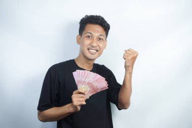 Şok olmuş ve yakışıklı Asyalı bir adamın beyaz duvar arkasında izole edilmiş bir şekilde poz verişi.