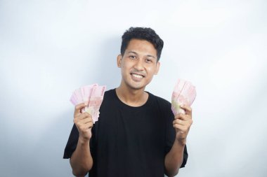 Şok olmuş ve yakışıklı Asyalı bir adamın beyaz duvar arkasında izole edilmiş bir şekilde poz verişi.