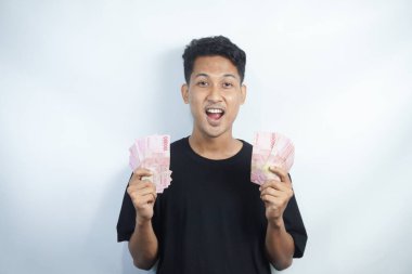 Şok olmuş ve yakışıklı Asyalı bir adamın beyaz duvar arkasında izole edilmiş bir şekilde poz verişi.