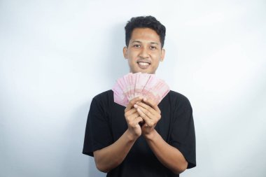 Şok olmuş ve yakışıklı Asyalı bir adamın beyaz duvar arkasında izole edilmiş bir şekilde poz verişi.