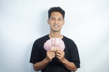 Şok olmuş ve yakışıklı Asyalı bir adamın beyaz duvar arkasında izole edilmiş bir şekilde poz verişi.