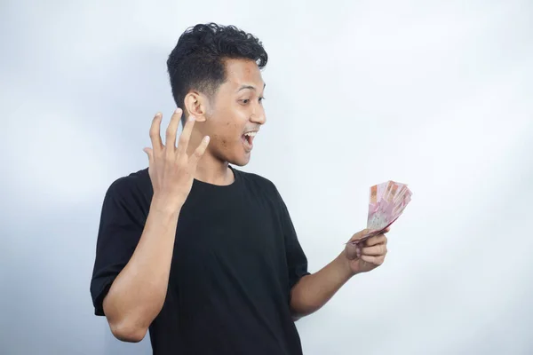 stock image Image of shocked and happy handsome young Asian man posing isolated over white wall background holding bunch of money cash