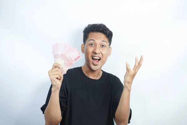 stock image Image of shocked and happy handsome young Asian man posing isolated over white wall background holding bunch of money cash