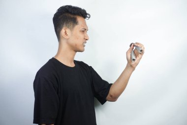 Siyah tişört giyen Asyalı adam egzersiz için tutamakları kullanıyor..