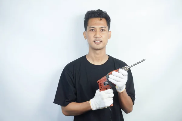 Hombre Asiático Positivo Con Camiseta Negra Sosteniendo Taladro Eléctrico Aislado — Foto de Stock