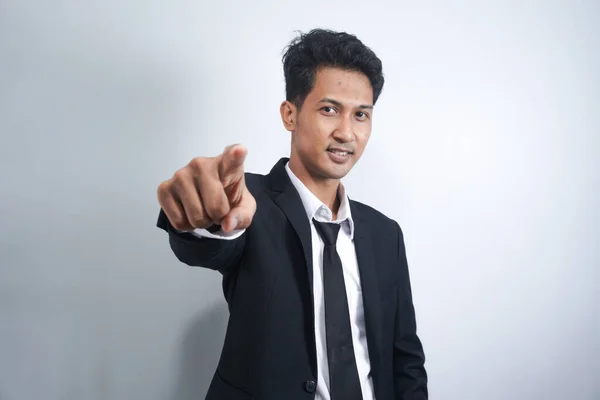 Stock image Man pointing. Cheerful young man pointing camera and smiling while standing isolated on white