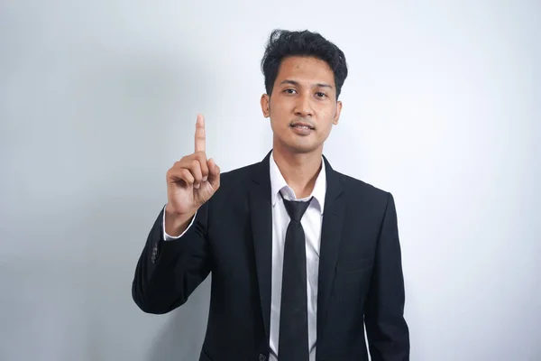 Attractive Young Asian Man Suit Pointing His Finger Isolated Gray — Stockfoto