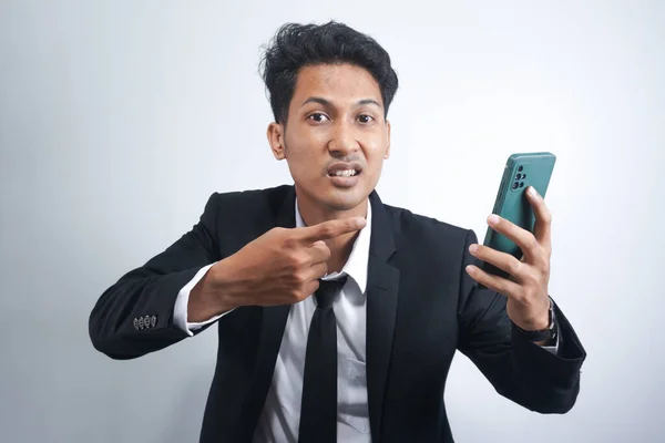 スーツ姿のハンサムなアジア系男性が怒って携帯電話を見て — ストック写真