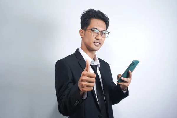 Good luck, nice work. Close-up portrait of satisfied, handsome Indonesian man show thumb-up in like, approval or recommend sign, give his permission, something in legit, white background