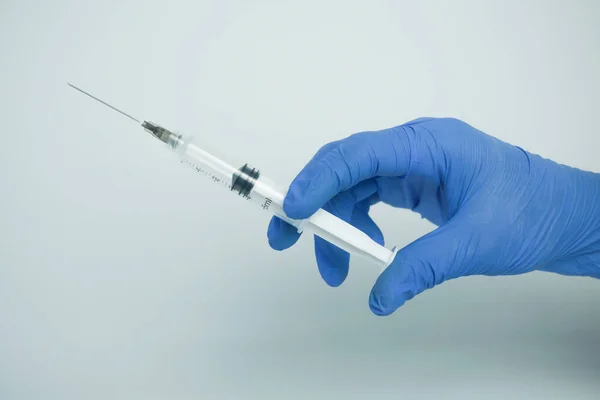 男性手戴蓝色手套 手持一个塑料塞环 内装液体 用于注射 在白色背景上隔离 治疗概念 — 图库照片
