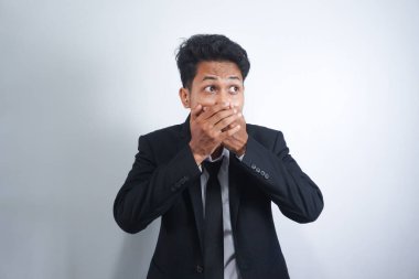 Şokta olan Asyalı genç adam elleriyle ağzını kapatıyor ve 