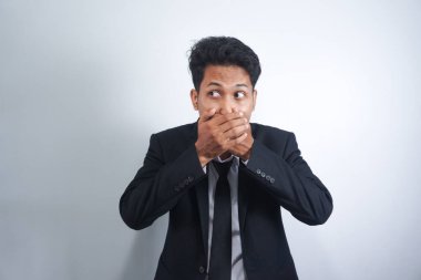 Şokta olan Asyalı genç adam elleriyle ağzını kapatıyor ve 