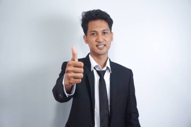 İyi şanslar, iyi iş. Tatmin olmuş, yakışıklı Asyalı bir adamın yakın plan portresi. Onay ya da tavsiye yazısı gibi bir şey göster. İzin ver, yasal, beyaz bir arka plan olsun.