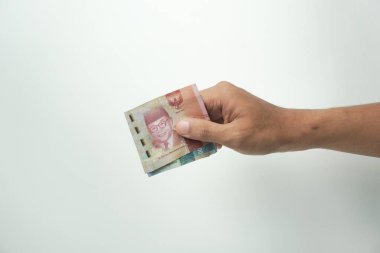 Beyaz arka planda el ele tutuşan Endonezya rupiası parası.