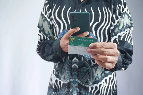 Holding a Healthy Indonesia Card (Health Insurance card from the Government of Indonesia) under the auspices of BPJS.take a photo of the BPJS card
