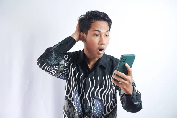 Молодой Азиат Удивленным Выражением Лица Держит Руках Смартфон Печатает Сообщения — стоковое фото
