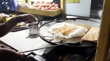 Balikpapan, 1 Temmuz 2023. Endonezya sokak yemekleri olan Egg Martabak ya da Martabak Eggs yapma ya da pişirme süreci. Yumurta, et ve baharatla doldurulmuş tuzlu tavada kızartılmış hamur işi..