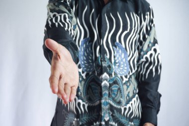 Genç Asyalı bir adam beyaz bir arkaplanda izole edilmiş el kamerasıyla selam veriyor..