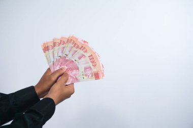 Rupiah parası tutan adamın eli beyaz arka planda izole edilir.