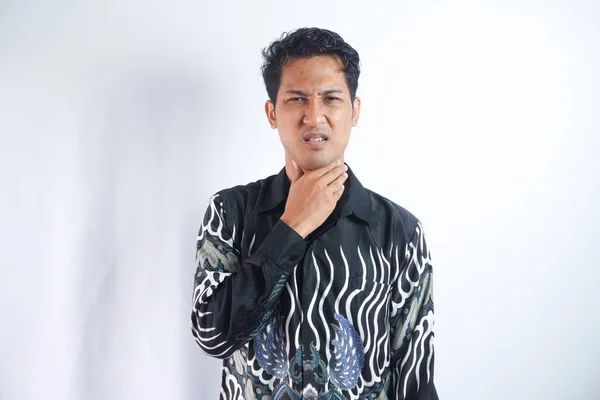 Młody Mężczyzna Ból Gardła Dotyka Szyi Nosi Koszulę Batik Jasnoszarym — Zdjęcie stockowe