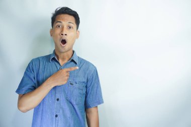 Omg, Cool Teklif. Asyalı genç bir adamın beyaz stüdyo arka planında izole edilmiş boş bir alanı göstermesine şaşırdım. Reklam metni veya reklam metni için yer ve mekan gösteren heyecanlı adam, afiş