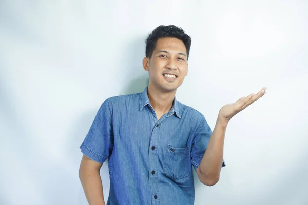 Unge Kjekk Asiatisk Mann Iført Blå Skjorte Isolert Bakgrunn Pekende – stockfoto