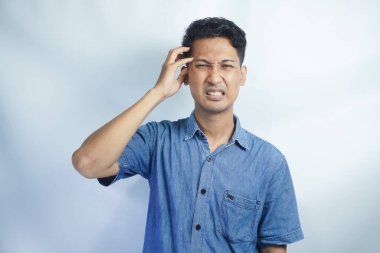 Yakışıklı delikanlı çünkü umutsuz ve stresli baş ağrısı acı izole arka plan üzerinde ağrı ve migren. Ellerini kafasına.